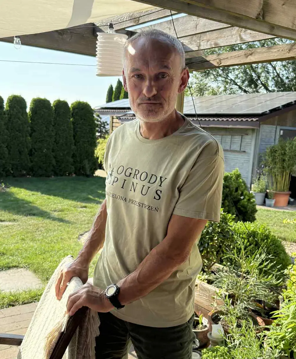 Ryszard Sobolewski - założyciel firmy Pinus Ogrody podczas profesjonalnej pielęgnacji ogrodu z widocznymi narzędziami ogrodniczymi